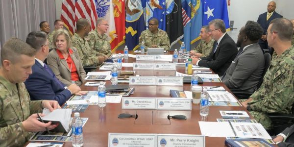 Military officers and officials meeting around a table.