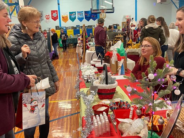 four women talking at holiday bazaar