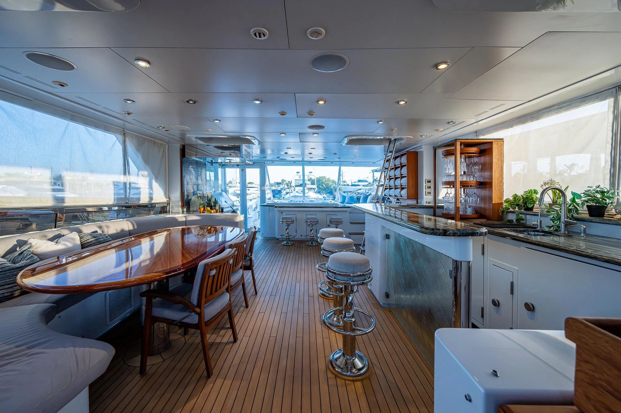 Luxurious yacht interior with wood finishes and bar seating.