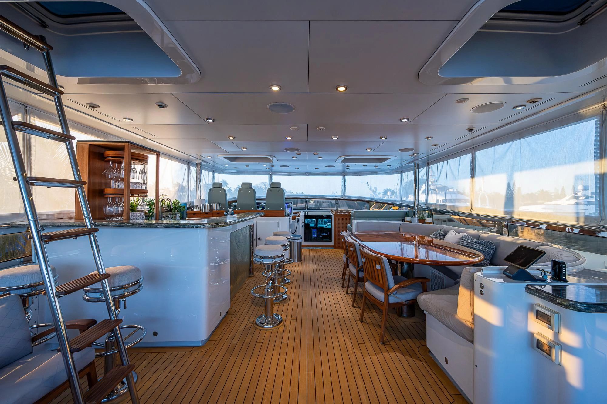 Luxurious yacht interior with a bar, dining area, and captain's seats.