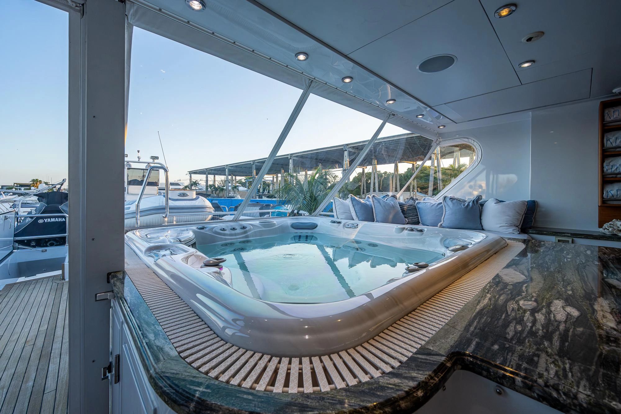 Luxurious hot tub on a yacht with marina views and cozy pillows.