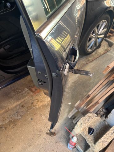 Car door with key inserted and spray can nearby.