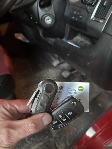 Hand holding a broken car key inside a vehicle.