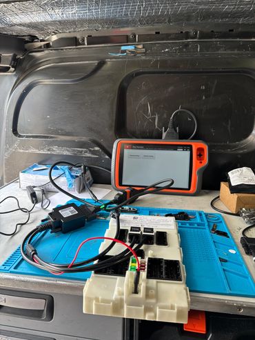 Diagnostic tools connected to a vehicle module on a workbench.