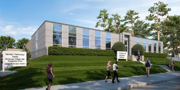 Modern college technology center building with people walking by.