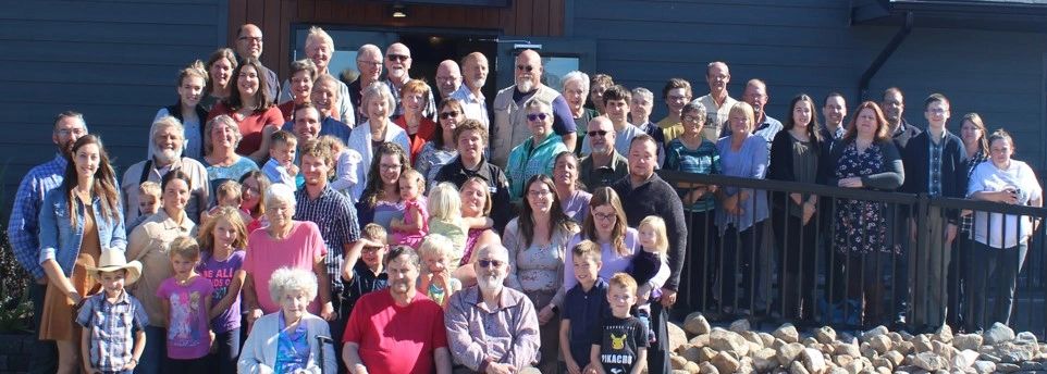 Large multi-generational family group posing outdoors.