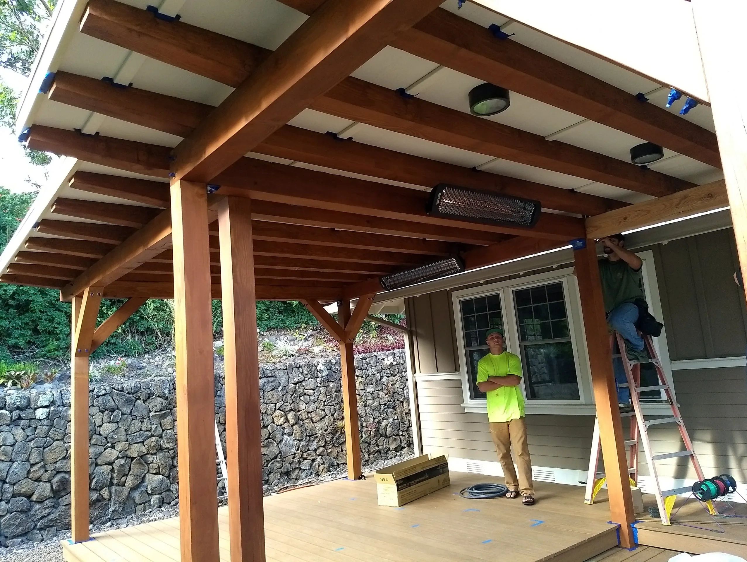 Wooden patio cover with workers.