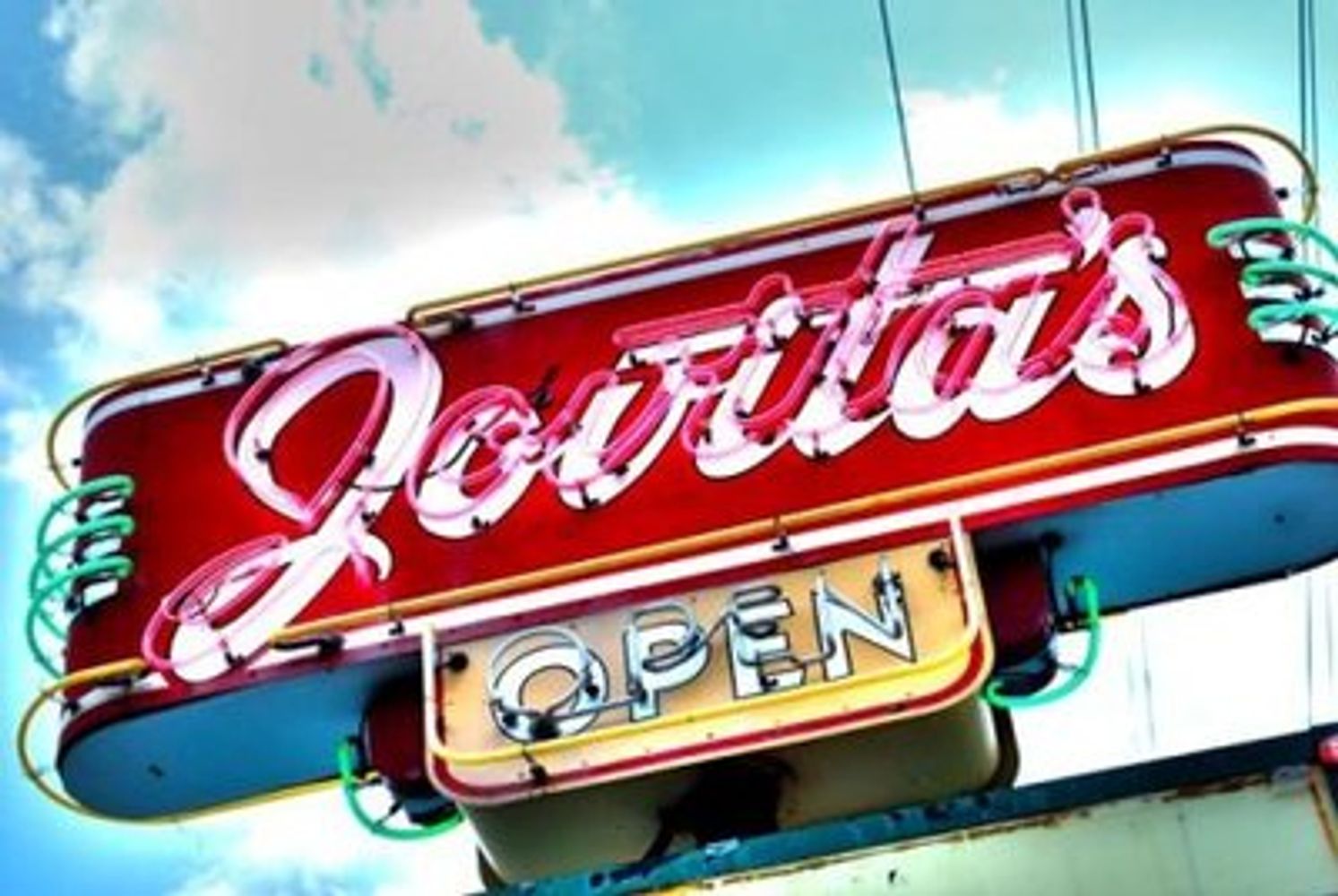 Neon sign reading 'Jovita's OPEN' against a blue sky.