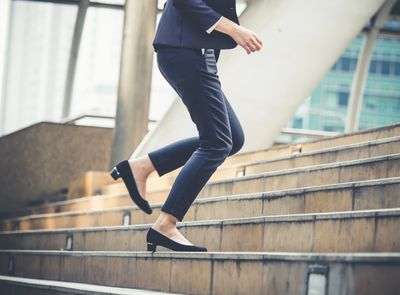 Close shot of legs of business woman walking up steps