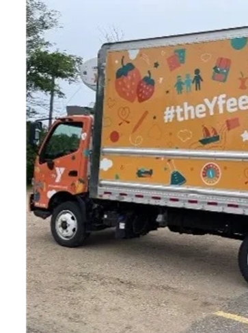 Orange Y-branded delivery truck with hashtag #theYfeet.