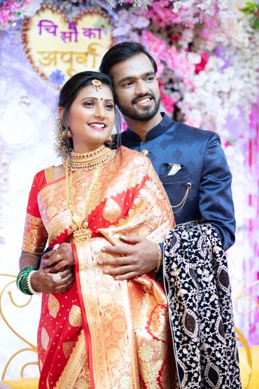 A happy couple dressed in traditional Indian wedding attire.