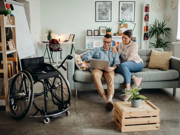 Couple looking at the laptop in hall