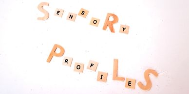 Words 'Sensory Profiles' spelled out with mixed letter tiles on white background.