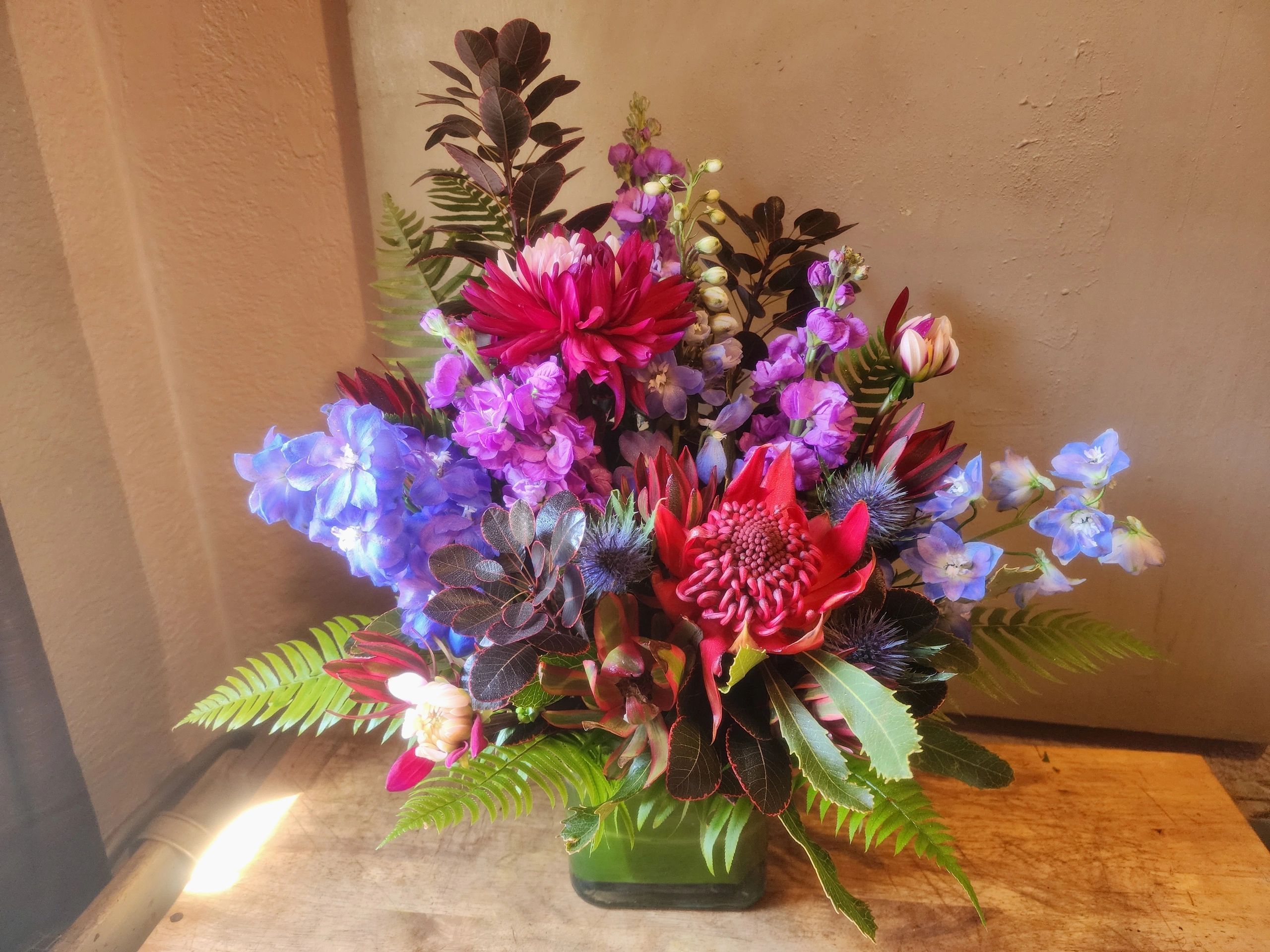 The Ares: Waratah, Dahlias, Delphinium. Smoke bush foliage piece, commanding color & fierce texture