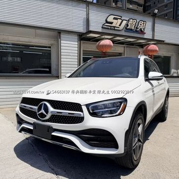 White Mercedes-Benz SUV parked outside a showroom with Chinese signage.