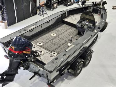 Fishing boat with 175hp outboard engine on a trailer.