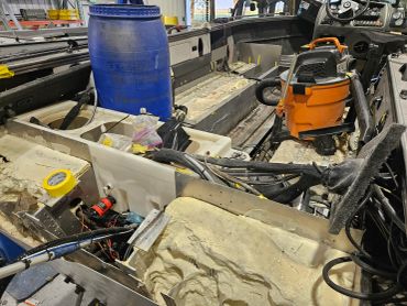 Interior of a boat under repair with tools and equipment.
