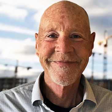 Smiling elderly bald man in a checked shirt.