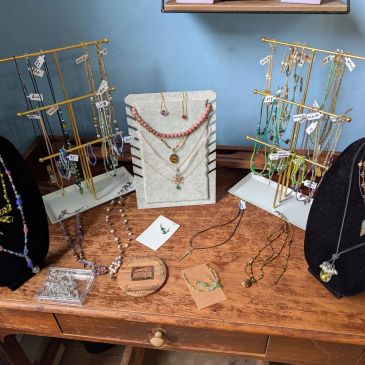 Variety of handmade jewelry displayed on a wooden table.