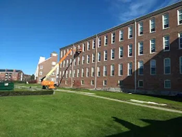 Stack of books next to pencils in a holder and a camera.