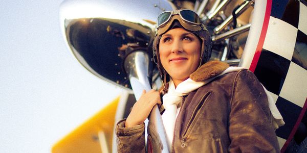 Images of a beautiful woman in front of a biplane with bomber jacket and old style flying helmet. Shot out at the Mack Mesa airport in western Colorado. Aviation photography is a speciality of Chad Mahlum.