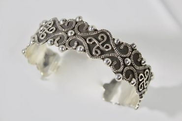 Intricate silver bracelet with detailed filigree design.