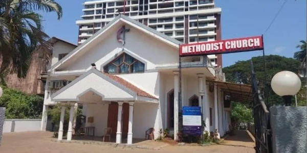 White Methodist Church building with a red sign.