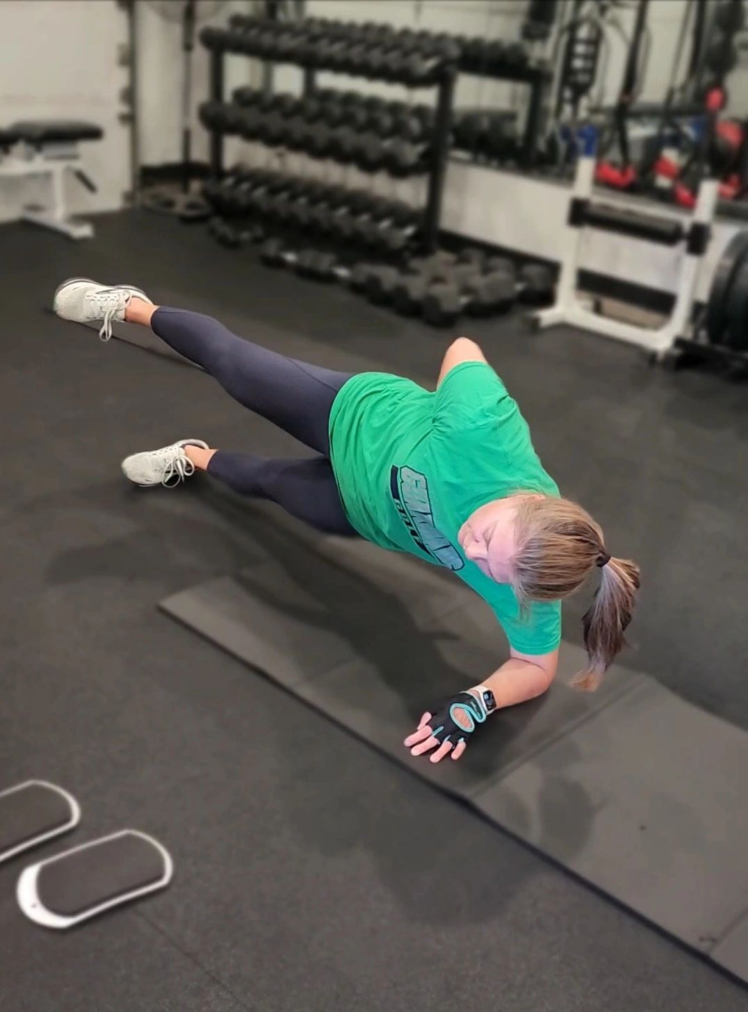 Woman doing side plank exercise in gym.