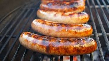 Alt="Five brats on a charcoal grill at MooSa's"