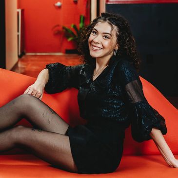 Ari, stylist, posing on the lip couch. 