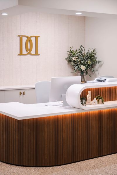 Modern office reception desk with decorative flowers and minimalist design.