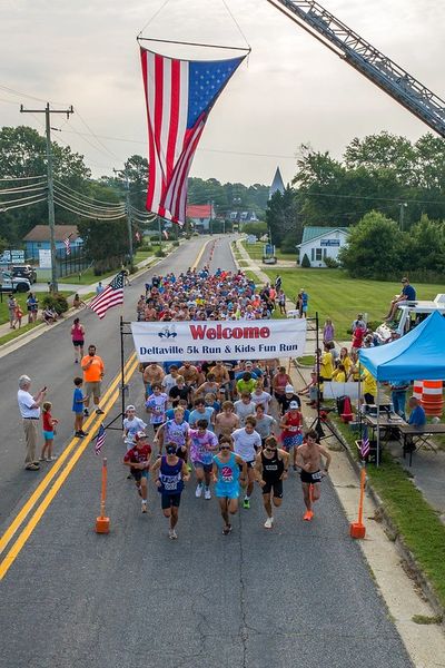 overhead photo of runners beginning race under the American flag