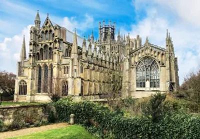 A grand Gothic-style cathedral with intricate stone carvings under a blue sky.