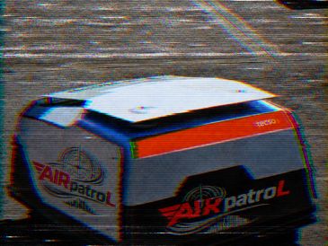A small robotic drone labeled 'AIR patrol' on the ground.