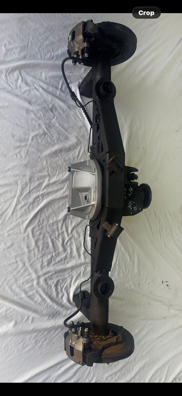 Car axle assembly with brake calipers and disc brakes.