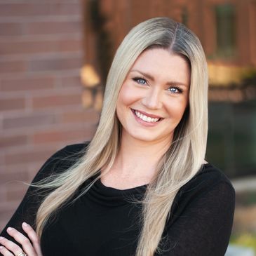 Smiling woman with long blonde hair wearing a black top.