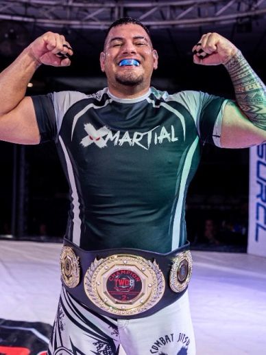 MMA fighter celebrating with championship belt.
