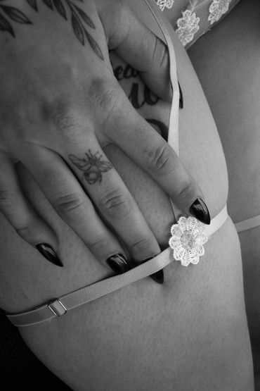 close up of floral garter on thigh with stiletto nails photo by Ian Reid