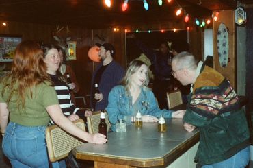 People socializing around a table in a warmly lit bar.