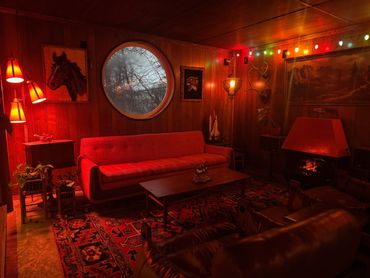 Cozy retro living room with warm red lighting and vintage decor.