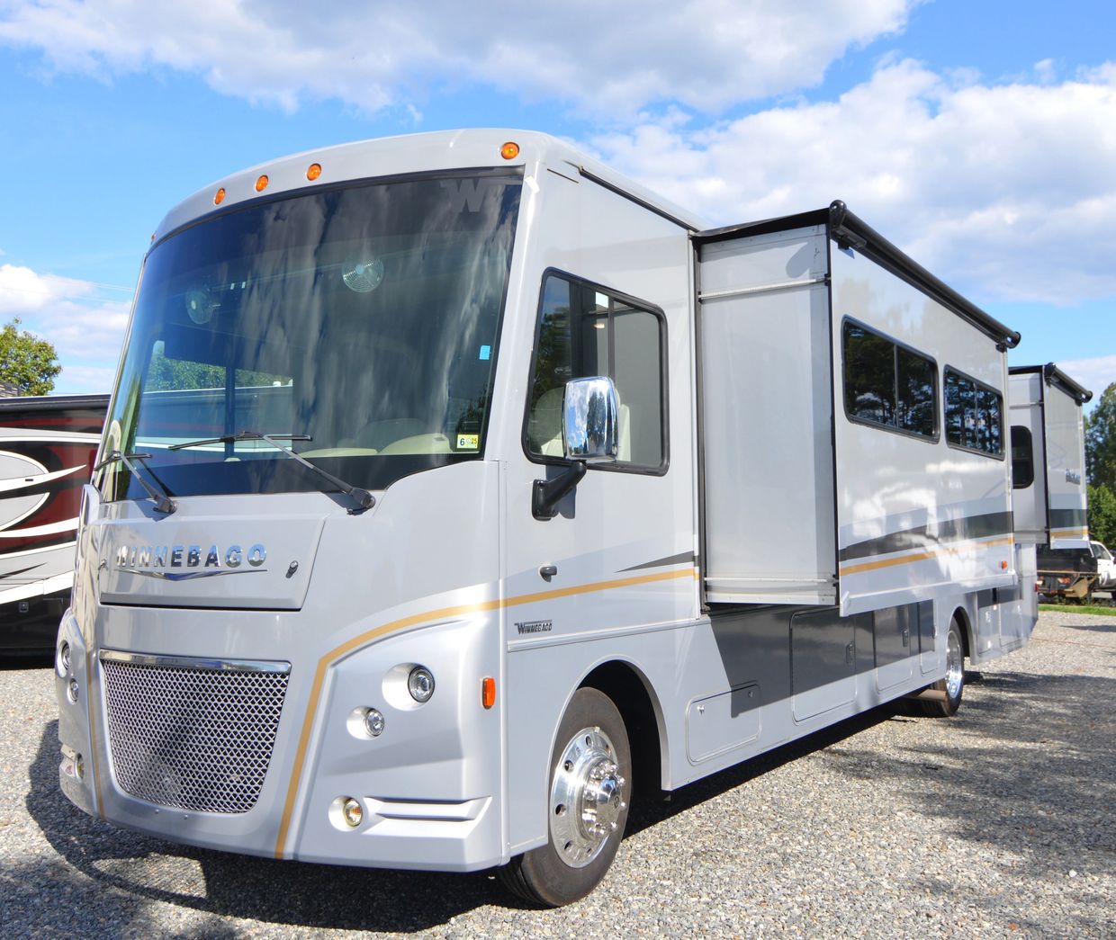 Silver Winnebago RV with slide-outs extended.