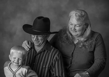 Grandparents doting over a toddler in a black and white image. 