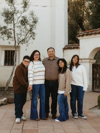 Family standing together outdoors in casual attire.