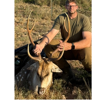 Man posing with a deer he hunted.
