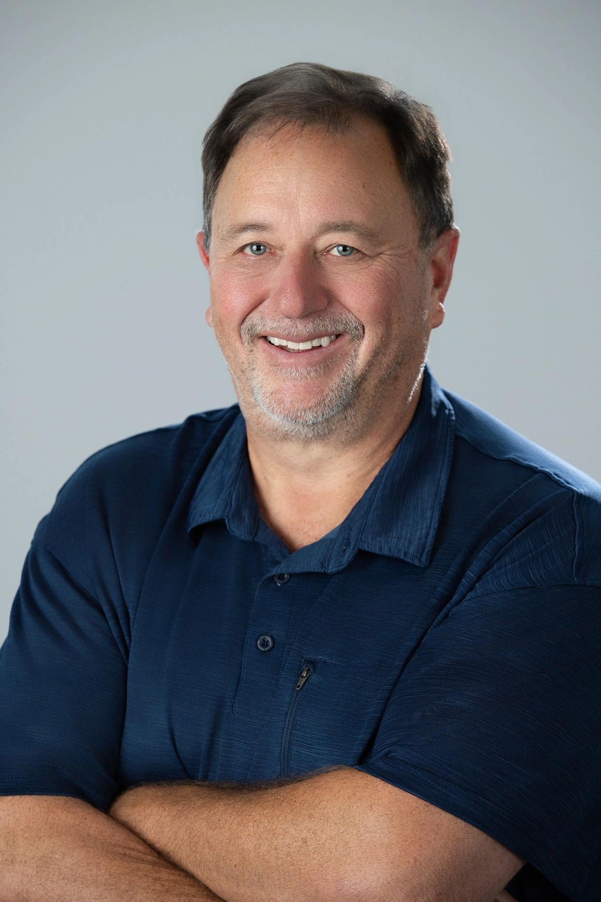 Smiling middle-aged man in a blue shirt.