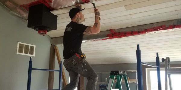 Owner Brayden Slattery installing shiplap in a rental suite

