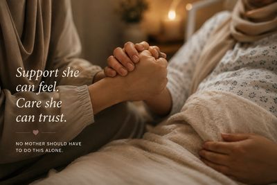 Pregnant muslim mother holding hands with a doula while in labour