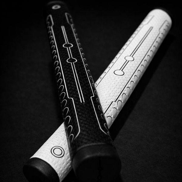 Black and white golf grips with geometric patterns on a dark background.
