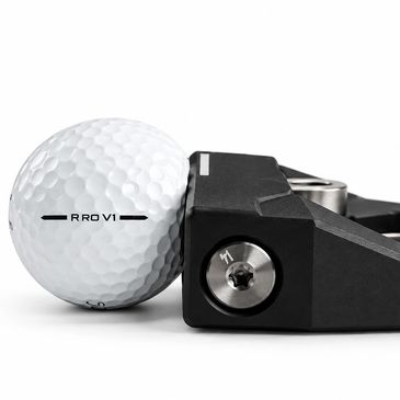 Close-up of a golf ball beside a putter head.