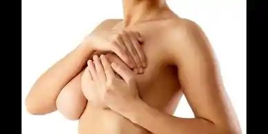 A naked woman covering her breast with hands